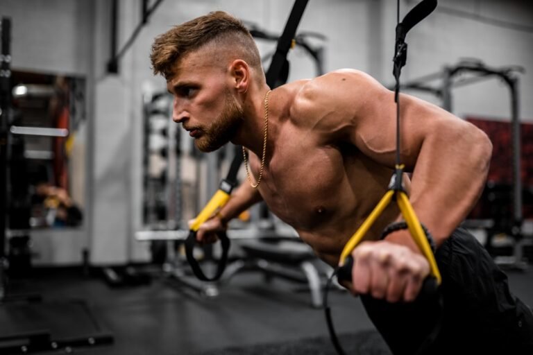 Hombre realizando un remo con cintas de suspensión TRX en el gimnasio